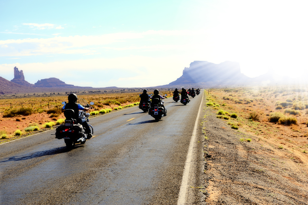 Motorbikers traveling in Monument Valley arizona with helmets on motorcycle