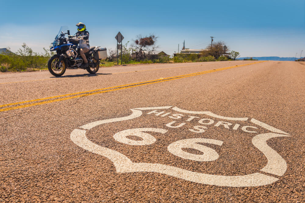 road with a route 66 sign drawn on it with a motorcycle in the background