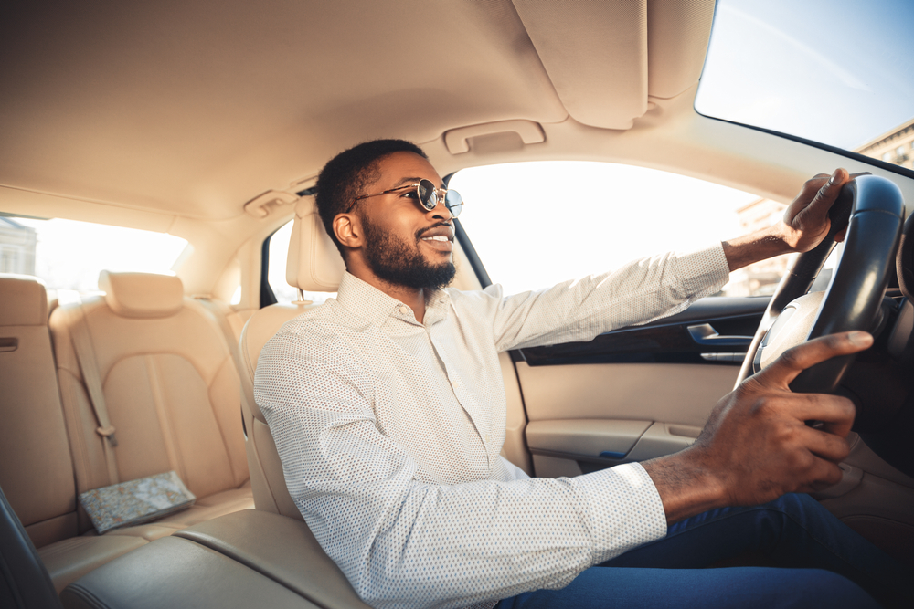african american driver smiling while driving car