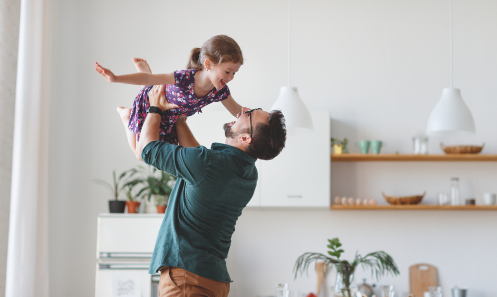 father holding daughter laughing