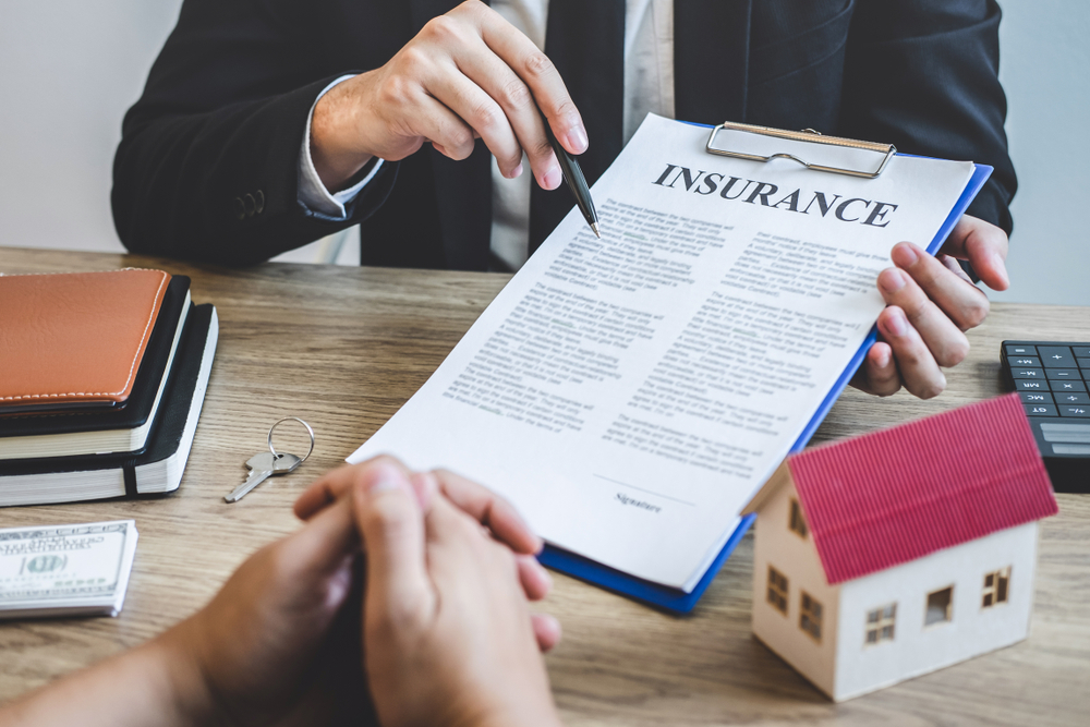 agent handing renters insurance paperwork to new renters