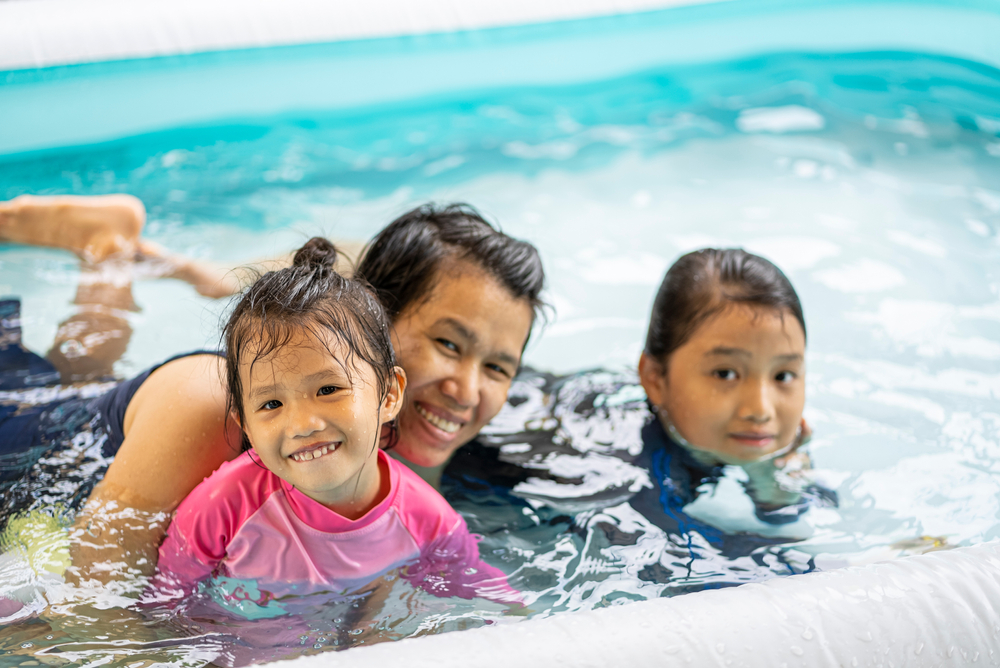 Mother with two young daughters in the pool
