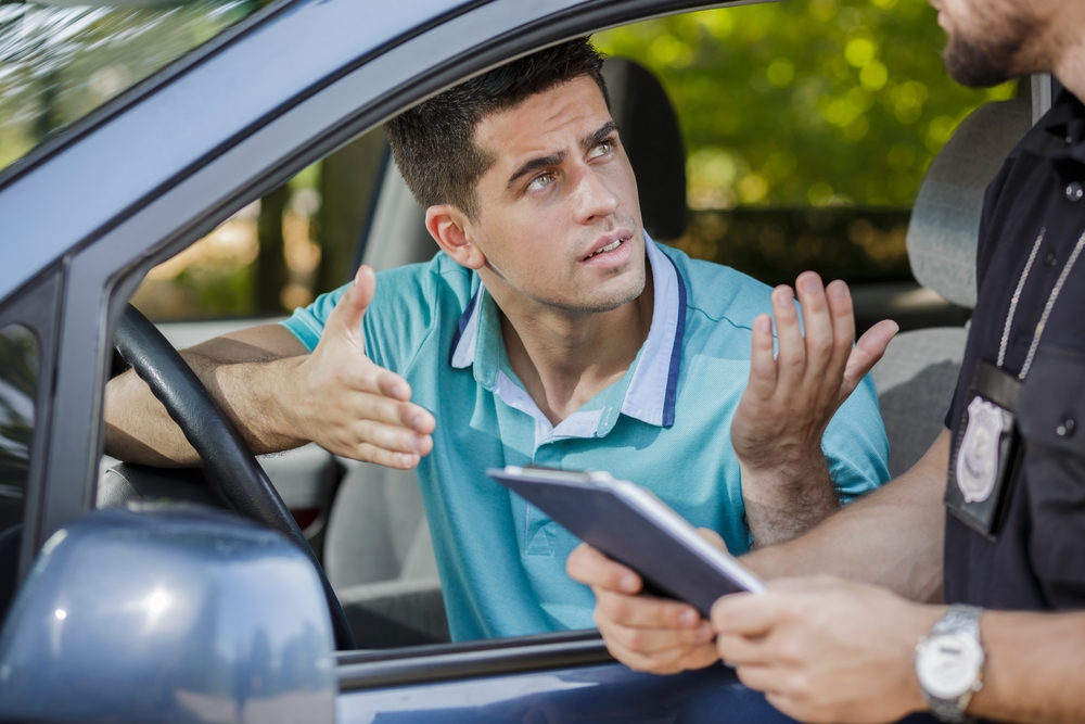 man getting pulled over by cop in car