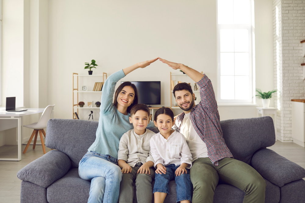 young family with two children sitting on couch