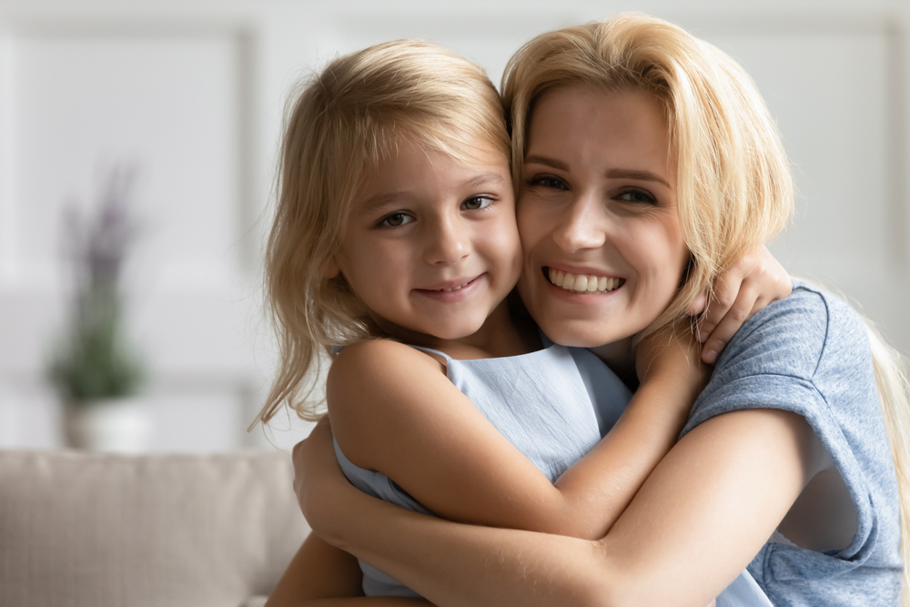 young mother holding daughter smiling
