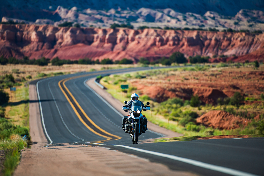 motorcycle driving down highway with arizona background