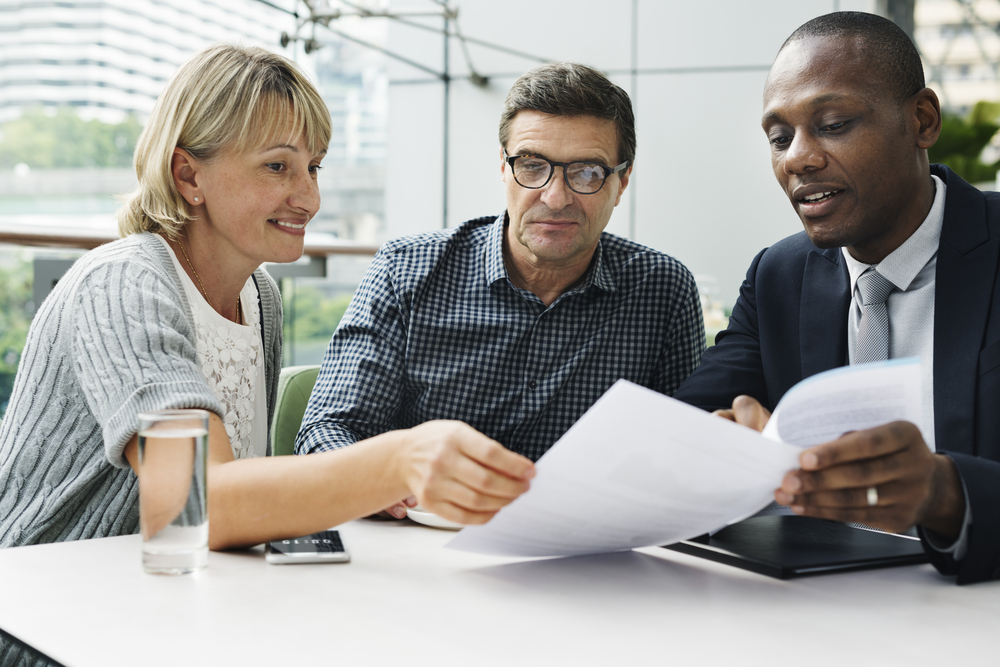 couple talking with insurance agent about policy