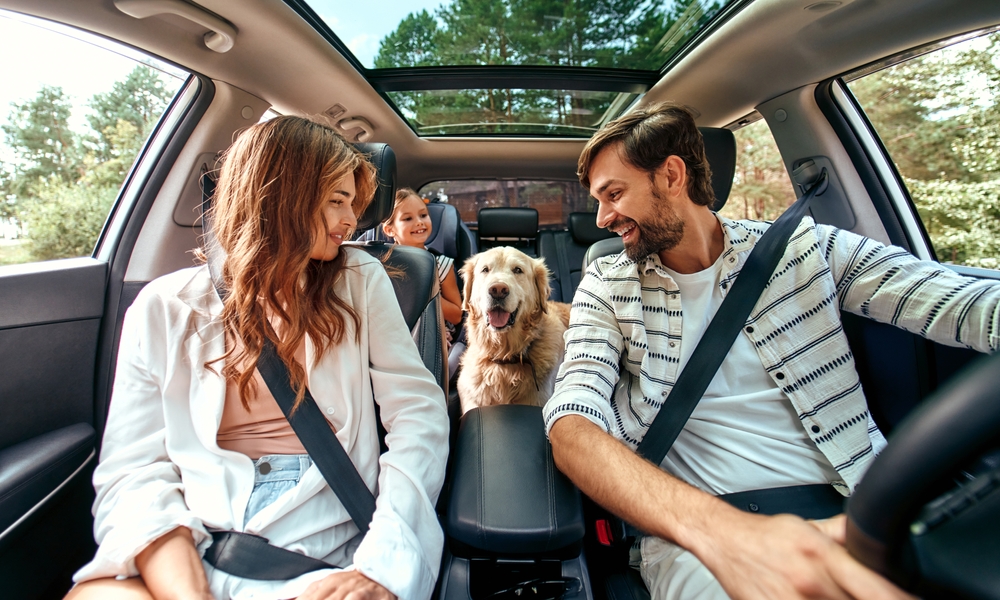 family smiling in car on road trip