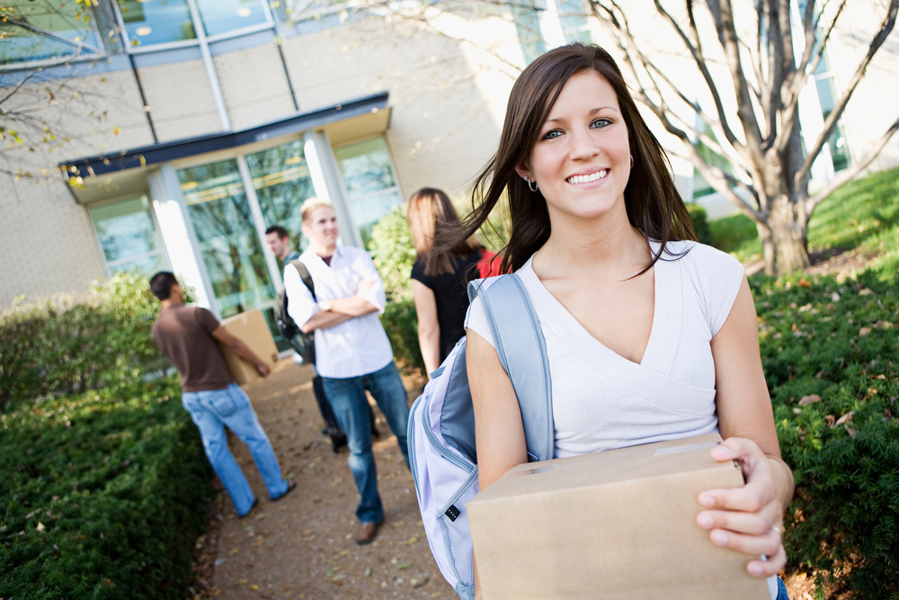 college student walking with box on campus